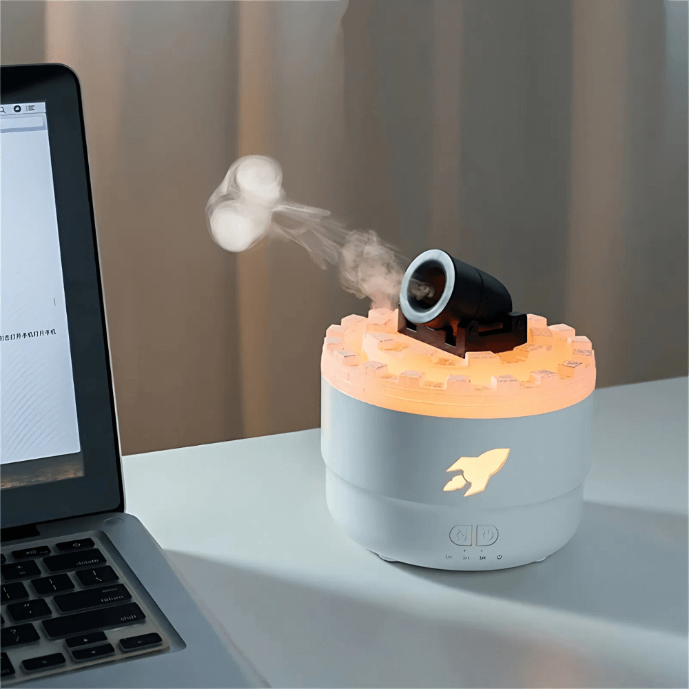 CannonAir™ desktop humidifier emitting vapor, featuring a sleek design and ambient lighting next to a laptop.